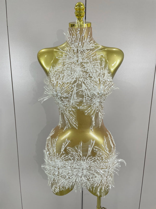 Mannequin wearing a sparkling white dress against a plain background